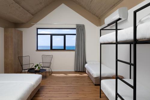 a bedroom with two bunk beds and a window at 180 Boutique Hostel in Tel Aviv