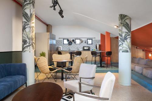 180 Boutique Hostel في تل أبيب: غرفة معيشة مع طاولة وكراسي