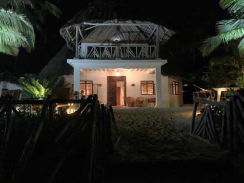 una casa en la playa por la noche en The Loft Zanzibar Kikadini Beach, en Jambiani