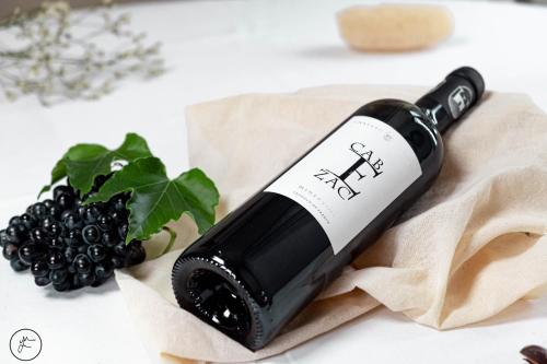 a bottle of wine sitting next to a bunch of blackberries at Logis hôtel et restaurant La Bastide Cabezac in Bize-Minervois