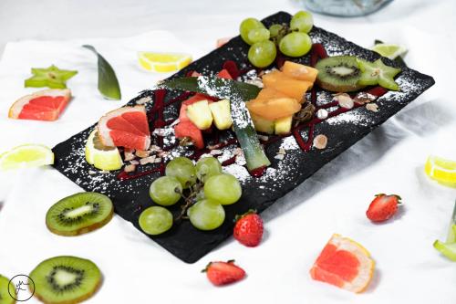 a plate of fruit on a white table at Logis hôtel et restaurant La Bastide Cabezac in Bize-Minervois