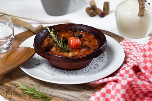a bowl of food on a plate on a table at Logis hôtel et restaurant La Bastide Cabezac in Bize-Minervois