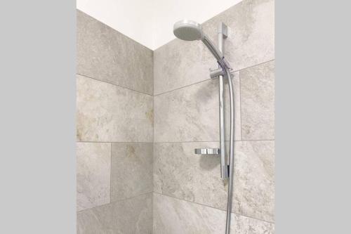 a shower with a glass door and a shower head at In Urbi, city appartement in Bressanone
