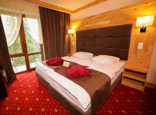 a bedroom with a large bed with red pillows on it at Romantik Spa Hotel in Yaremche