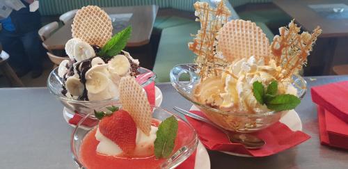 two bowls of ice cream and desserts on a table at gasthof pension rössl in Nova Ponente