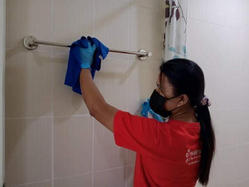 a woman is holding a blue shirt on a towel rack at Cha-Am Fish Star in Cha Am