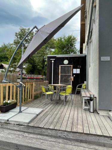 a deck with a table and chairs and an umbrella at Apartment WELLNESS Vlčková in Vlčková