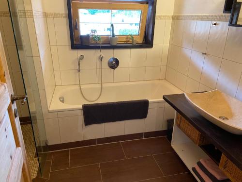 a bathroom with a bath tub and a sink at Unser Dahoam in Wallgau