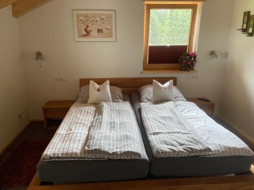 two twin beds in a room with a window at Unser Dahoam in Wallgau