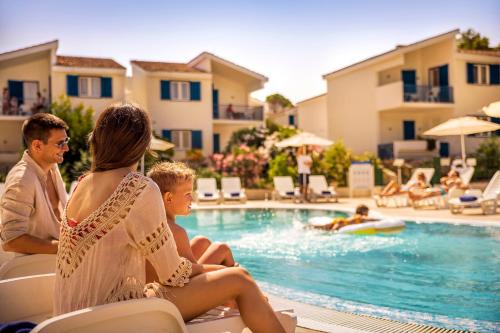 a family sitting by a swimming pool at a resort at Aminess Vival Port9 Residence in Korčula