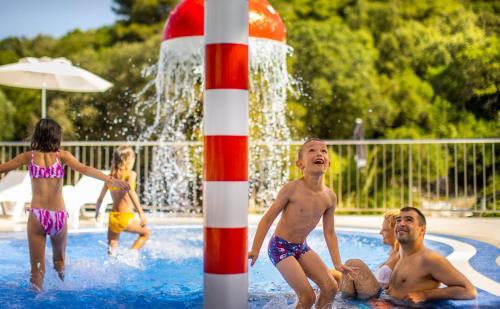 a group of young children playing in a swimming pool at Aminess Vival Port9 Residence in Korčula