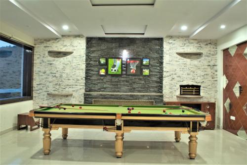 a pool table in a room with a brick wall at Tavisha Kanatal Hills Chamba in Kanatal