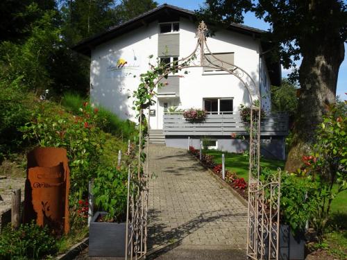 einen Gartenweg, der zu einem weißen Haus führt in der Unterkunft Hotel Wanderlust B&B in Gernsbach