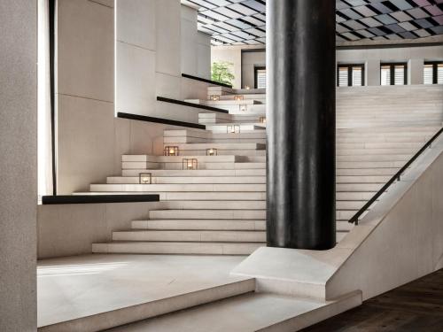 a staircase in a building with a black pole at CHAO Sanlitun Beijing in Beijing