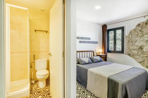 una camera con letto e un bagno con servizi igienici di Can Salva charm on the Costa Brava a Torroella de Fluviá
