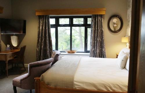 a bedroom with a large bed and a window at Heather Glen Country House in Ainstable