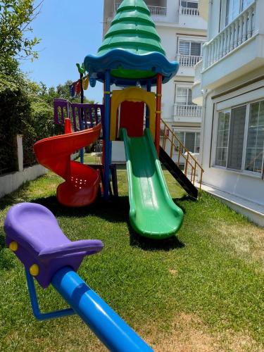 a playground with a slide in a yard at BELKA GOLF RESİDENCE Deluxe apt Poolside BELEK in Belek