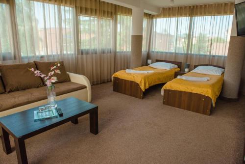 ヤロスワフにあるHotel Turkusのベッド2台とソファが備わるホテルルームです。