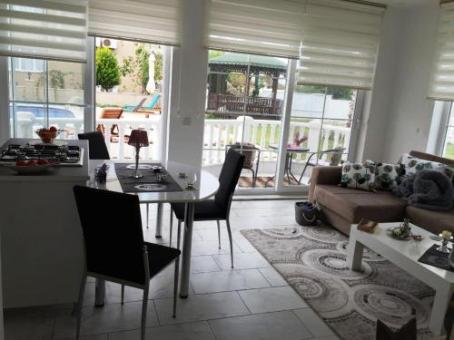 a living room with a table and a couch at BELKA GOLF RESİDENCE Deluxe apt Poolside BELEK in Belek