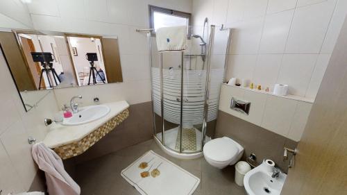 La salle de bains est pourvue d'une douche, de toilettes et d'un lavabo. dans l'établissement Cozy wood apartment with great view to Nazareth, à Nazareth