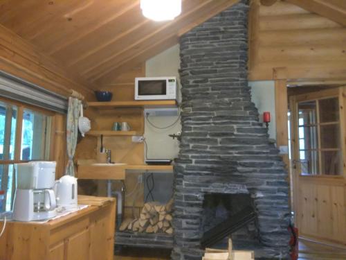 ein Wohnzimmer mit einem Steinkamin in einem Haus in der Unterkunft Holiday Cabin Kerimaa 53 in Savonlinna