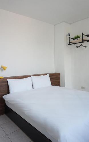 a white bed with white sheets and pillows in a bedroom at 埔里城民宿 PuliTown BNB in Puli