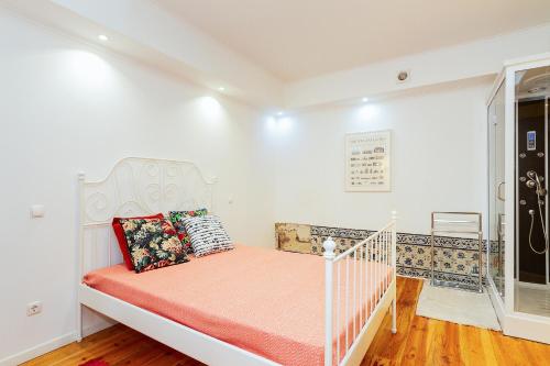 ein weißes Bett in einem Zimmer mit Fenster in der Unterkunft Alfama First Floor in Lissabon