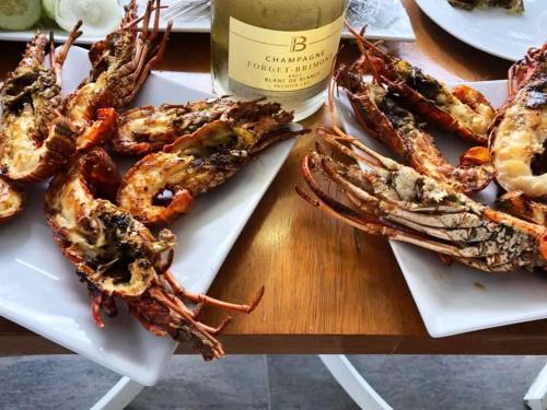 a table with a plate of lobsters and a bottle of wine at BELKA GOLF RESİDENCE Poolside apt1 Belek in Belek