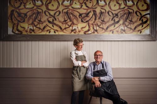 a woman standing next to a man sitting on a bench at Landgasthof Barenwirt in Petzenkirchen