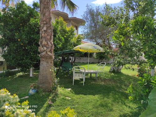 a table and umbrella in the yard of a house at ziogas apartments in Plataria