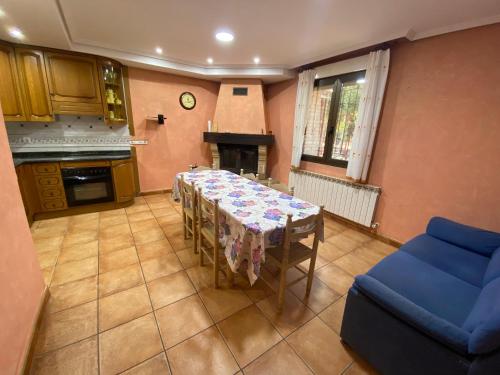 a dining room with a table and a blue couch at Casa La Fuente in Huércanos