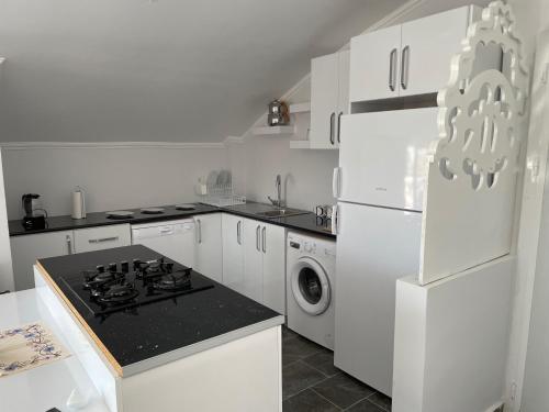 a white kitchen with a stove and a refrigerator at BELKA GOLF RESİDENCE Poolside apt1 Belek in Belek