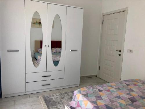 a bedroom with a white cabinet with two mirrors at BELKA GOLF RESİDENCE Poolside apt1 Belek in Belek