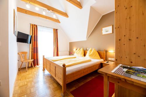 a bedroom with a bed and a desk in a room at Weingut-Gästehaus Birnstingl in Gamlitz
