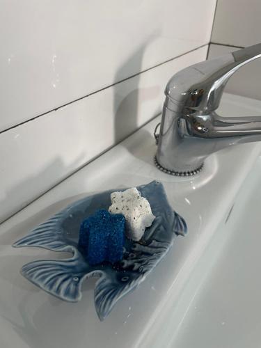 ein blaues Gericht auf einem Waschbecken neben einem Wasserhahn in der Unterkunft Enjoy Las Canteras in Las Palmas de Gran Canaria