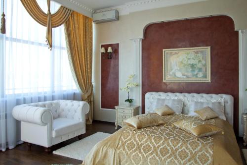 1 dormitorio con 1 cama blanca y 1 silla blanca en Sobkoff, en Khmelʼnytsʼkyy