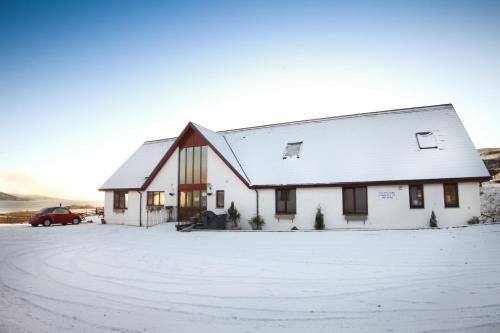 una casa blanca con nieve en el suelo en Arle Lodge, en Tobermory