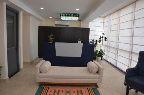 a living room with a couch and a white screen at Lords Eco Inn Belagavi in Belgaum