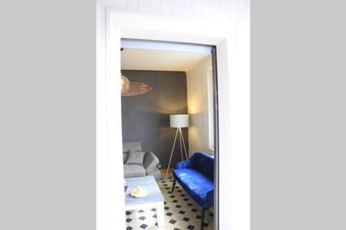 un salon avec un canapé bleu et un miroir dans l'établissement Le Lagon de Cayeux 4 à 8 couchages 50 mètres de la plage, à Cayeux-sur-Mer