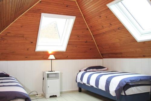 deux lits dans une chambre avec deux fenêtres dans l'établissement Le Lagon de Cayeux 4 à 8 couchages 50 mètres de la plage, à Cayeux-sur-Mer