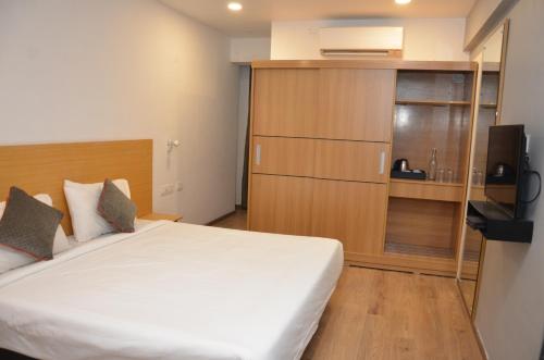 a bedroom with a bed and a tv in a room at Lords Eco Inn Belagavi in Belgaum