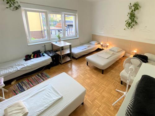 Sala de estar con 2 camas y mesa en Guesthouse GreenSLO en Liubliana