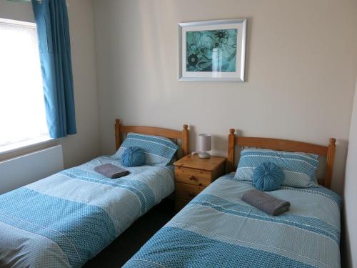 two beds sitting next to each other in a bedroom at 3 Bedroom Home with Welcome Breakfast near Beaches in Ramsgate