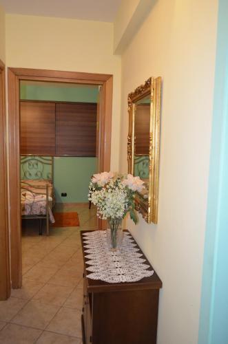 a vase of flowers on a table with a mirror at B&B Le Colonne in Montefusco