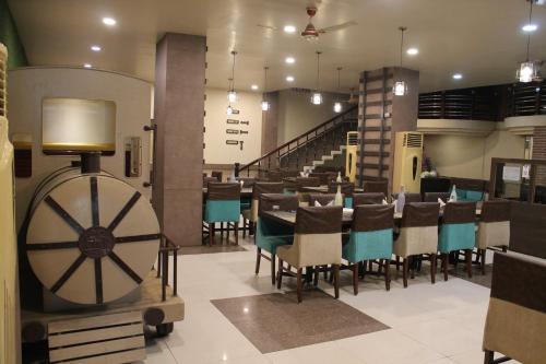 uma sala de jantar com uma mesa e cadeiras e uma roda em Hotel Padmini International- Sigra em Kakarmatha