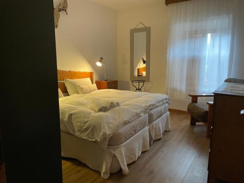 een slaapkamer met een groot bed en een spiegel bij Casa Montana 1600 in Sovramonte