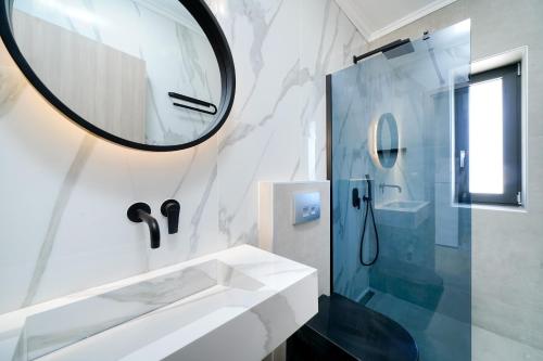 a bathroom with a sink and a mirror at Videre Luxury Suites in Potos