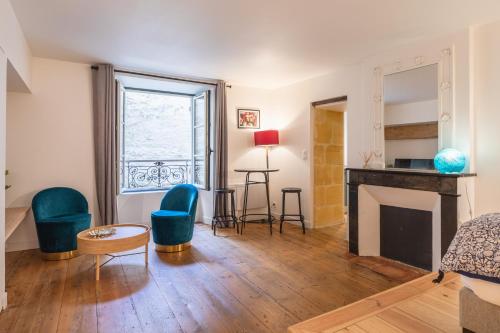 - un salon avec une cheminée et des chaises vertes dans l'établissement Gabylou, à Bordeaux