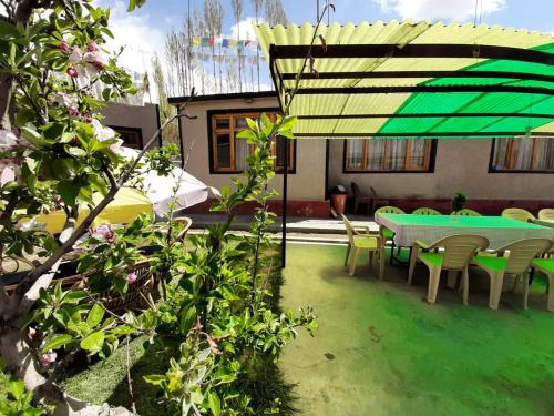 a patio with a green table and chairs at Rabyang Guest House and Homestay in Leh