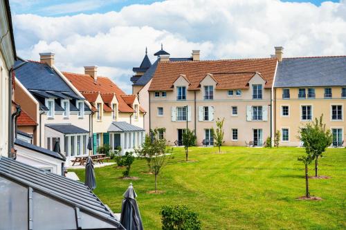 a large building with a green lawn in front of it at Staycity Aparthotels near Disneyland Paris in Bailly-Romainvilliers